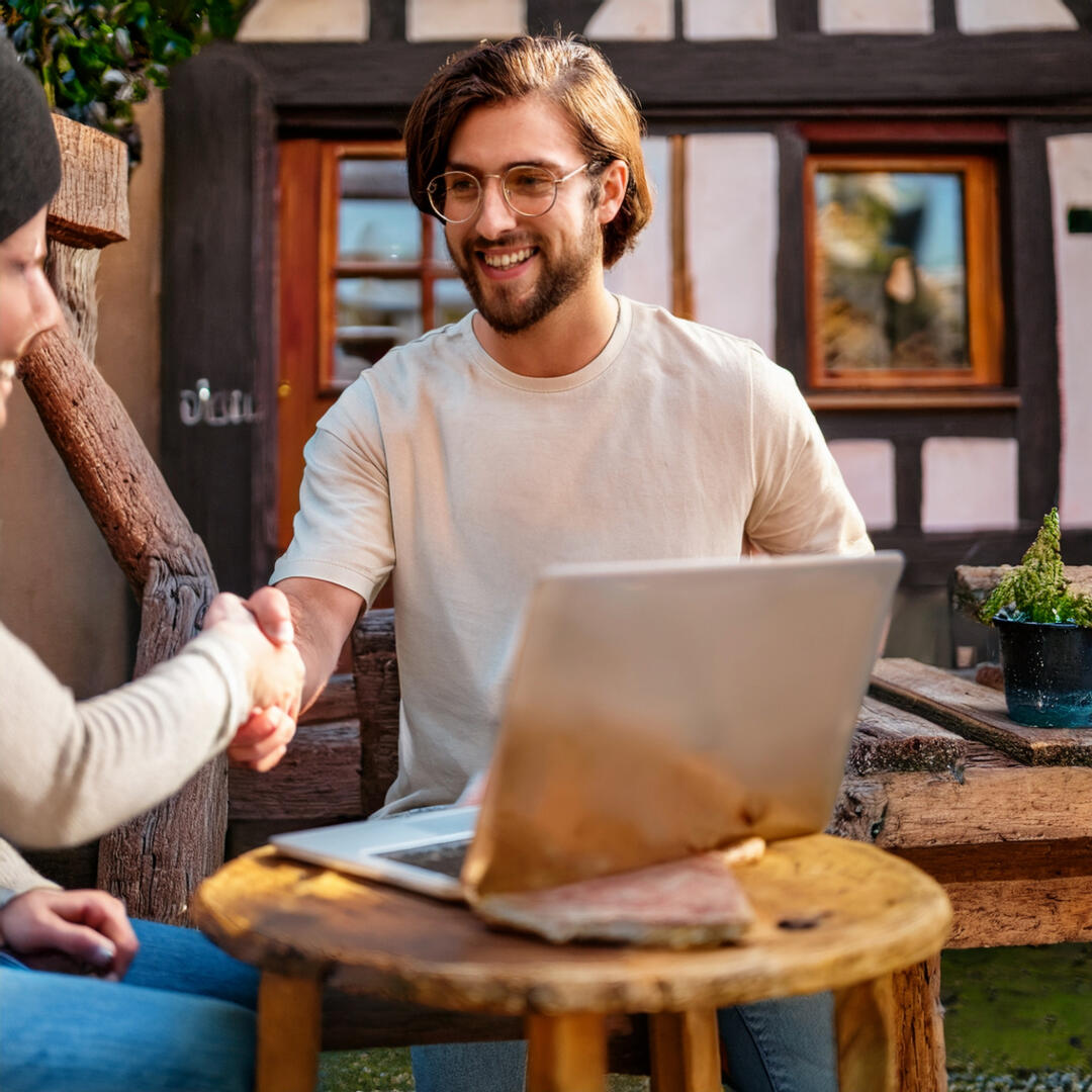 Partenariat humain entre influenceur et établissement local alsacien Créateur de contenu rencontrant un commerçant devant une boutique à colombages en Alsace
